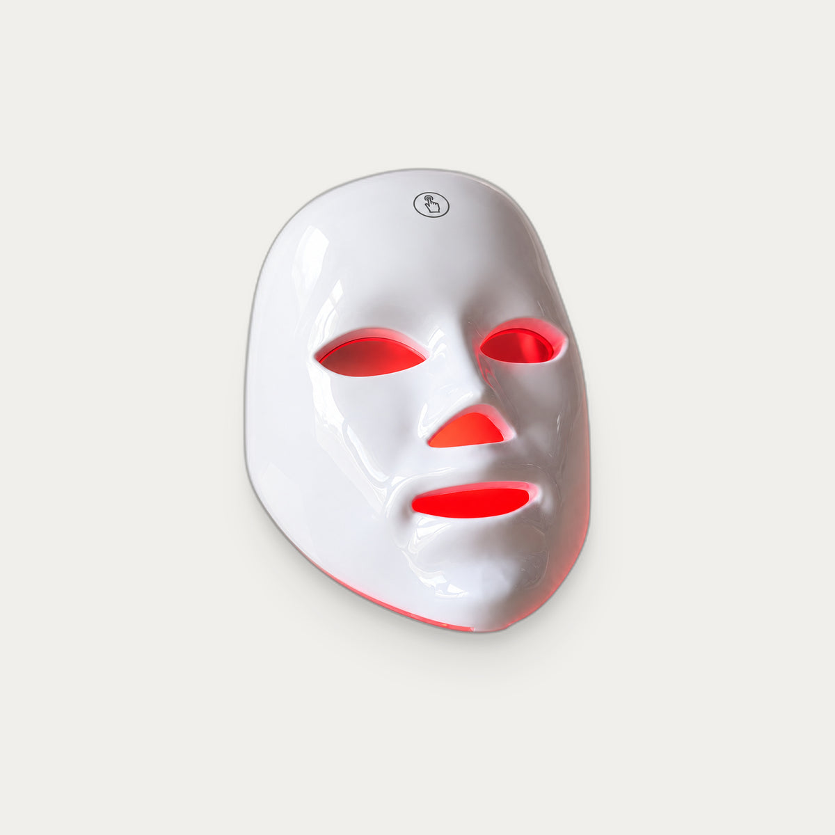 Máscara facial LED ELVYRA con la luz roja encendida, packshot de estudio sobre fondo gris cálido