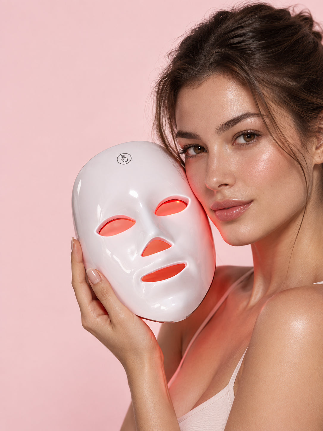 Mujer sosteniendo la máscara facial LED de ELVYRA con la luz roja encendida